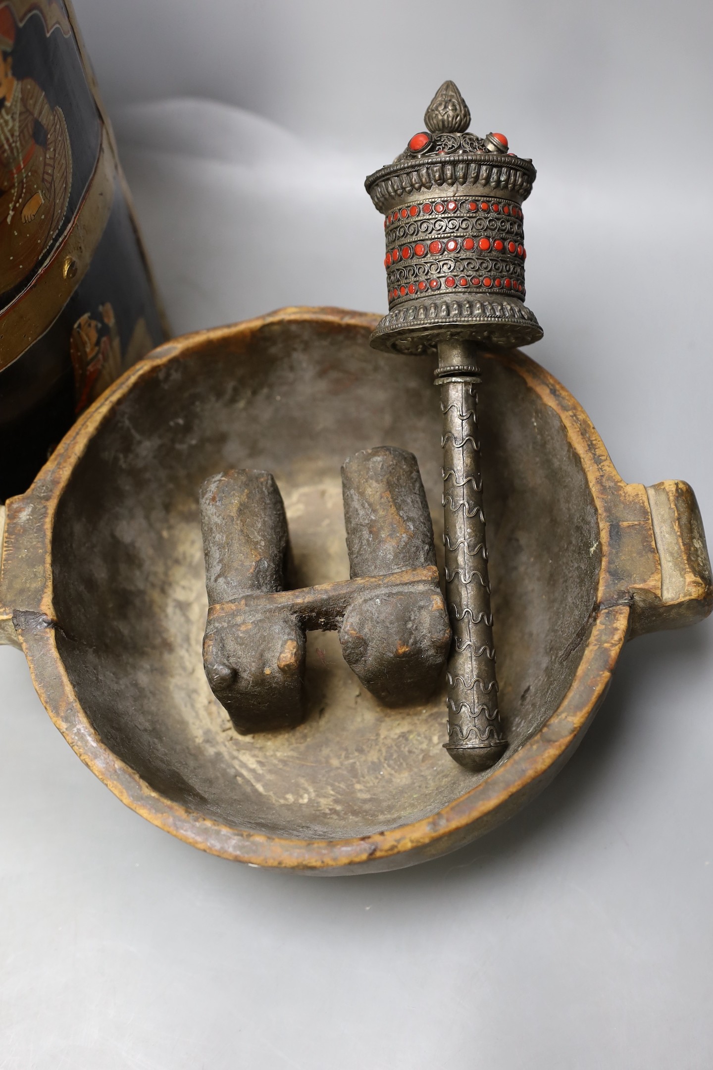 An African carved wood bowl, a Tibetan prayer wheel and a Persian waste basket